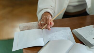 person sitting on wooden table holding a pencil